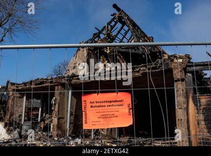 Nortorf, Germany. 02nd Mar, 2021. A sign reading 'Is confiscated. No trespassing' by the state police hangs on a fence in front of the remains of an end-terrace house that was almost completely destroyed in an explosion. One day after the explosion in the house in Nortorf (Rendsburg-Eckernföde district), a 54-year-old female resident is still missing. Credit: Axel Heimken/dpa/Alamy Live News Stock Photo