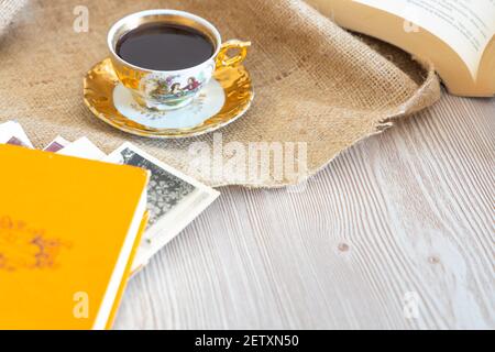 Turkısh Coffee in classic cup, wooden background with romantic rose petals, book about love among old vintage pictures, decorate with beige color, Stock Photo
