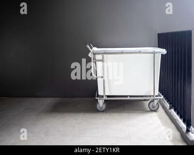 Empty hotel housekeeping maid laundry trolley without bed sheets, pillowcases and towels from guest in the hotel with copy space. Stock Photo
