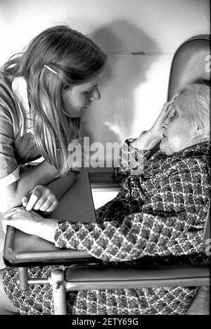 Sixteen year old school girl on work experience as a care assistant in care home. Talking to elderly Female resident Stock Photo