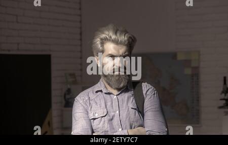 Confident bearded handsome business man in blue shirt holding laptop and smiling at camera. Stock Photo