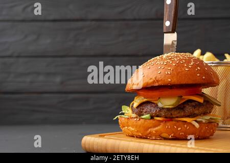 Fresh burger and fries on black wooden background Stock Photo