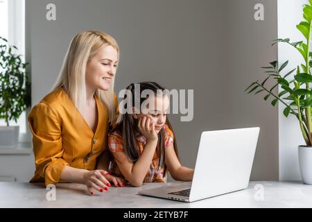 Helpful mother explaining to daughter about using a laptop Stock Photo