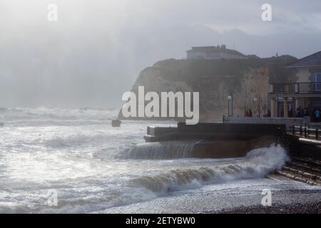 Rough sea with large waves breaking over the seafront in Freshwater, Isle of Wight during a storm with high winds and torrential rain Stock Photo