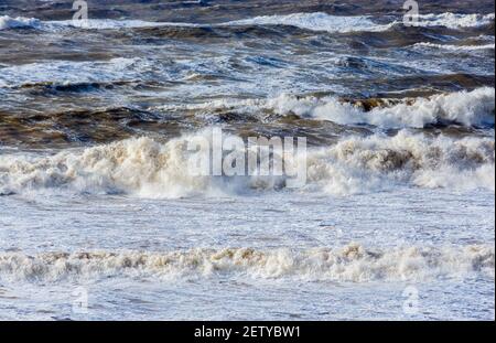 Breaking waves and surf in the rough sea off Hanover Point in the Isle of Wight during bad weather with storm force heavy winds Stock Photo