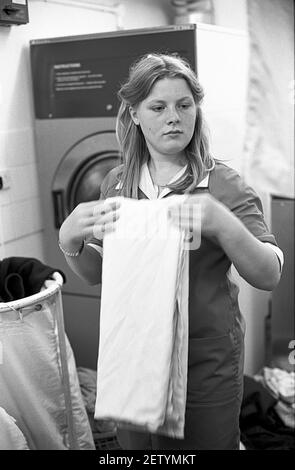 Sixteen year old school girl on work experience as a care assistant in care home. Doing the washing. Stock Photo