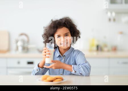 Cute Little Afro Girl Drinking Milk From Glass Stock Photo