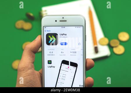 Kharkov, Ukraine - February 28, 2021: Liqpay app on Apple iPhone in App Store, close up, man is using application for making transfer and payment Stock Photo