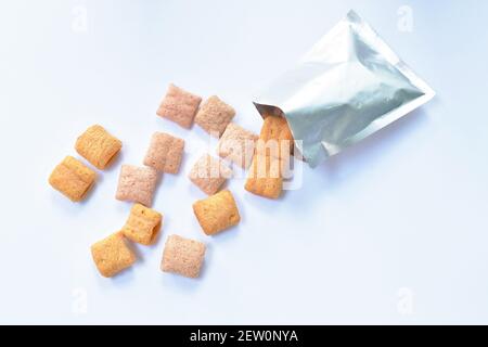 colorful crispy biscuit stuffed cream pouring from aluminium foil package on white background Stock Photo