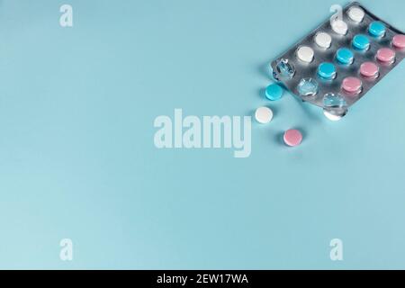 Medicines and pills. Blue, pink and white pills. Multicolored medicines on a pastel blue background. Copy space Stock Photo