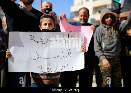 February 26, 2021: Azaz, Syria. 26 February 2021. A demonstration against Syrian President Bashar al-Assad is held in the city of Azaz, in north western Syria, under the title â€œThere is no legitimacy for Assad and his electionsâ€. Protesters held banners denying legitimacy to the Syrian President Bashar al-Assad and the forthcoming presidential elections, while also calling for the release of members of the opposition arrested by the Syrian government. Some placards denounced Bashar al-Assad for using chemical weapons, with a banner reminding of the chemical attack in Ghouta on 21 August 20 Stock Photo