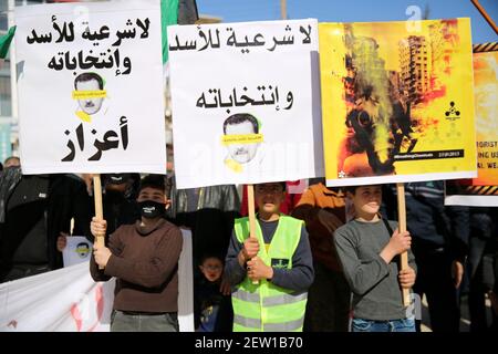 February 26, 2021: Azaz, Syria. 26 February 2021. A demonstration against Syrian President Bashar al-Assad is held in the city of Azaz, in north western Syria, under the title 'There is no legitimacy for Assad and his elections''. Protesters held banners denying legitimacy to the Syrian President Bashar al-Assad and the forthcoming presidential elections, while also calling for the release of members of the opposition arrested by the Syrian government. Some placards denounced Bashar al-Assad for using chemical weapons, with a banner reminding of the chemical attack in Ghouta on 21 August 20 Stock Photo