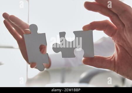 Business concept: Hand holding two pieces of a puzzle Stock Photo