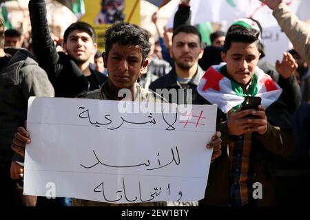 February 26, 2021: Azaz, Syria. 26 February 2021. A demonstration against Syrian President Bashar al-Assad is held in the city of Azaz, in north western Syria, under the title 'There is no legitimacy for Assad and his elections''. Protesters held banners denying legitimacy to the Syrian President Bashar al-Assad and the forthcoming presidential elections, while also calling for the release of members of the opposition arrested by the Syrian government. Some placards denounced Bashar al-Assad for using chemical weapons, with a banner reminding of the chemical attack in Ghouta on 21 August 20 Stock Photo