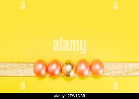 Bright pastel minimalistic concept of easter holiday with pearl colored eggs on golden ribbon, flat lay with copy space Stock Photo
