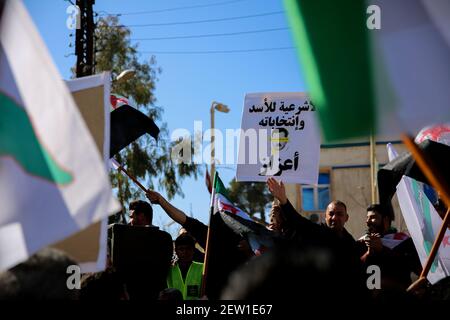 February 26, 2021: Azaz, Syria. 26 February 2021. A demonstration against Syrian President Bashar al-Assad is held in the city of Azaz, in north western Syria, under the title â€œThere is no legitimacy for Assad and his electionsâ€. Protesters held banners denying legitimacy to the Syrian President Bashar al-Assad and the forthcoming presidential elections, while also calling for the release of members of the opposition arrested by the Syrian government. Some placards denounced Bashar al-Assad for using chemical weapons, with a banner reminding of the chemical attack in Ghouta on 21 August 20 Stock Photo