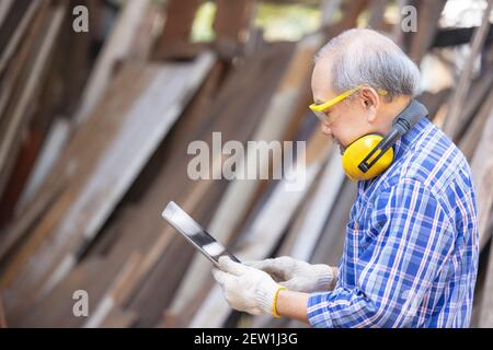 Male carpenter in a construction workshop, using a digital tablet Stock Photo