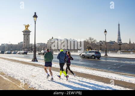 France, Paris, joggers on the Alexandre III bridge under the snow Stock Photo