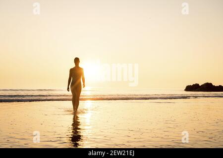 France, Cotes d'Armor, Plérin, young woman bathing at sunrise at Martin plage Stock Photo