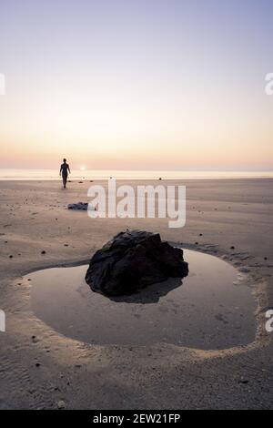 France, Cotes d'Armor, Plérin, young woman bathing at sunrise at Martin plage Stock Photo