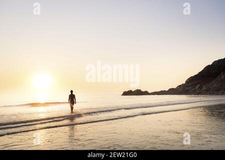 France, Cotes d'Armor, Plérin, young woman bathing at sunrise at Martin plage Stock Photo