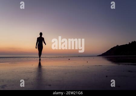 France, Cotes d'Armor, Plérin, young woman bathing at sunrise at Martin plage Stock Photo