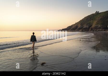 France, Cotes d'Armor, Plérin, young woman bathing at sunrise at Martin plage Stock Photo