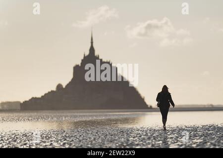 France, Manche, the Mont-Saint-Michel, woman silhouette crossing the Mont-Saint-Michel bay