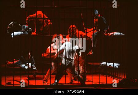 assaulted in prison, centre in white: Phil Daniels (Alex) in A CLOCKWORK ORANGE 2004 at the Barbican Theatre, London EC2  06/02/1990  a Royal Shakespeare Company production  written by Anthony Burgess in collaboration with Ron Daniels  music by The Edge & Bono  design: Richard Hudson  lighting: David Hersey  choreography: Arlene Phillips  fights: Malcolm Ranson  director: Ron Daniels Stock Photo