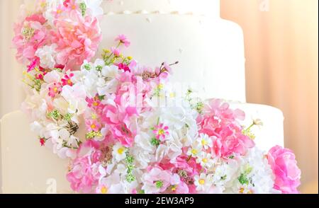 White wedding cake with flowers On a happy couple's day Stock Photo