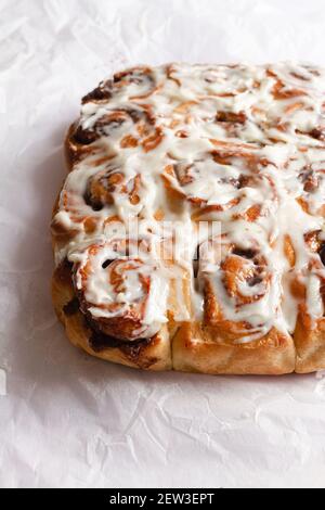 Freshly baked cinnamon rolls covered with a mascarpone cheese frosting. Stock Photo