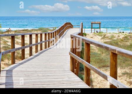 Wooden empty board walk leading through sand dunes to Mediterranean Sea and beach of Los Arenales Arenals del Sol, no people. Costa Blanca, Europe, Sp Stock Photo