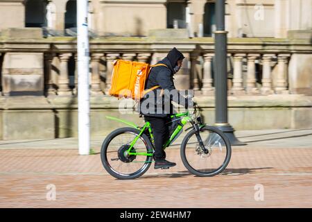 Just Eat fast food delivery cyclist in a city centre, UK Stock Photo