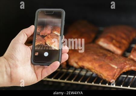 Taking photo of the Beef Ribs being cooked on Barbecue Grill. Backyard BBQ party concept Stock Photo