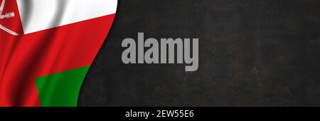 Oman flag on concrete wall. Banner with fabric texture of the flag of Oman. Stock Photo