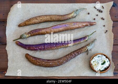 Stewed chinese eggplant with sauce and spice on wooden  surface top view Stock Photo