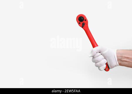 mans hand holding instrument for unwind or tighten nuts and bolts hard to reach places. ratchets and sockets in hand tools. Home improvement tools con Stock Photo
