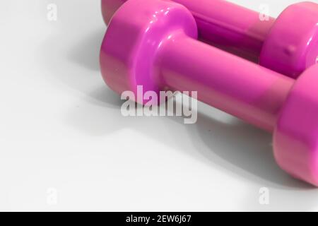 Two styled rubberized pink dumbbells isolated on white background. Top view. Flatly. The concept of a healthy lifestyle and sports, fitness. Women's s Stock Photo