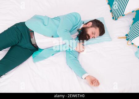 Sleeping in fashionable clothes. Recovery and recharging. Feel tired and sleepy. Sleepy guy in formal clothes sleep bed top view. Lack of sleep. Need more sleep. Evening time. Businessman exhausted. Stock Photo