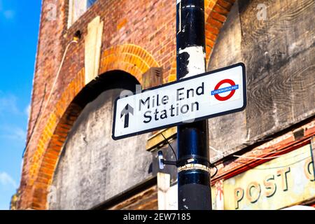 Mile End Underground Station sign in front of a run down former post office building, Tower Hamlets, London, UK Stock Photo