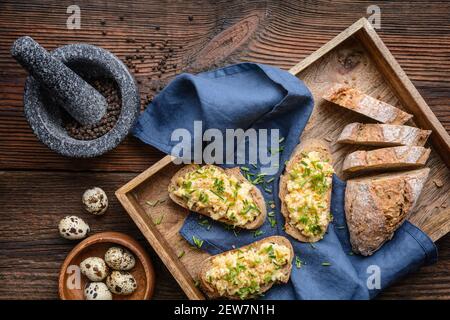 Delicious and healthy breakfast, scrambled quail eggs topped with chopped chives Stock Photo