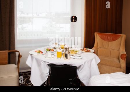 Served breakfast in a hotel room on a roll-out table on a white tablecloth Stock Photo