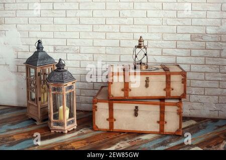 Decorative vintage suitcases and lamps against the background of a textured wall Stock Photo