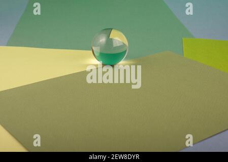 Green paper texture. Minimal geometric composition with glass ball. Abstract background. Stock Photo