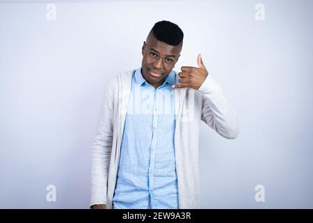 Young handsome african american man wearing casual clothes smiling doing phone gesture with hand and fingers like talking on the telephone Stock Photo