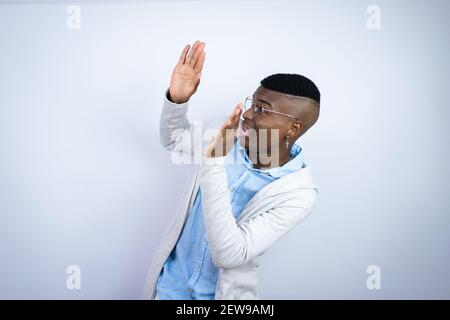 Young handsome african american man wearing casual clothes scared with his arms up like something falling from above Stock Photo