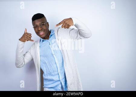 Young handsome african american man wearing casual clothes doing the “call me” gesture with his hands. Stock Photo