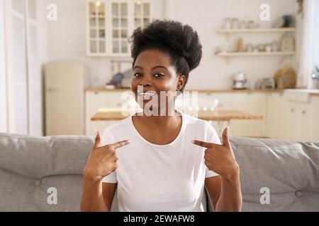 Smiling African woman vlogger influencer make video call, looking at camera, recording vlog at home. Stock Photo