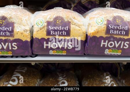 three loaves of sliced bread for toast and sandwiches on shelves for sale in supermarket, UK Stock Photo