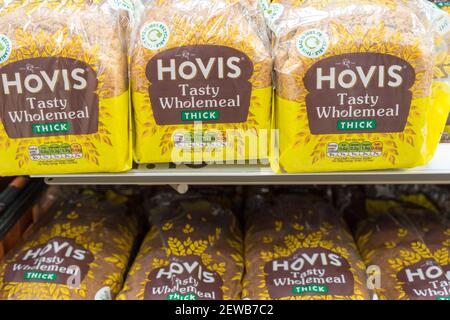 three loaves of sliced bread for toast and sandwiches on shelves for sale in supermarket, UK Stock Photo